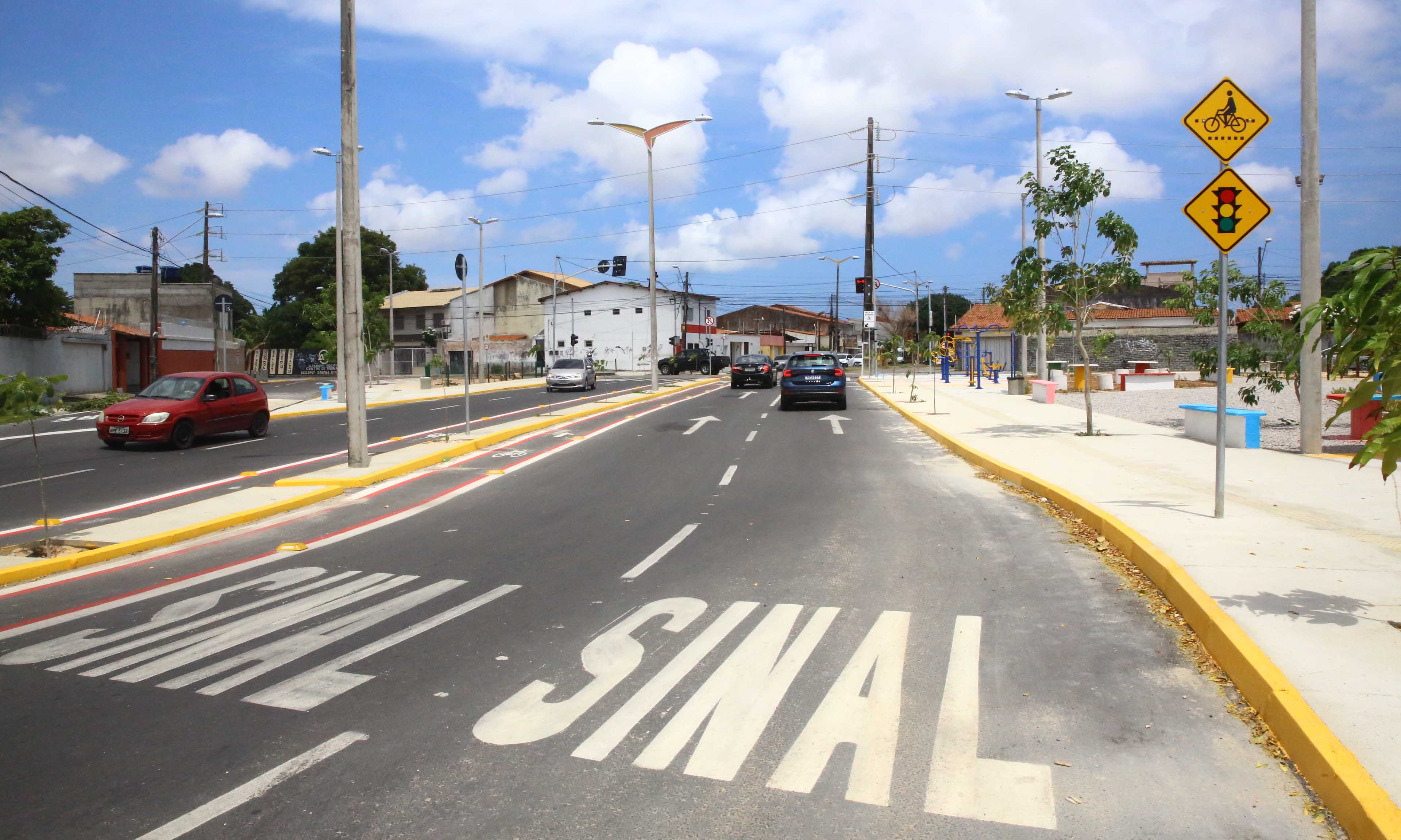 a foto mostra uma rua com sinalização horizontal escrita 